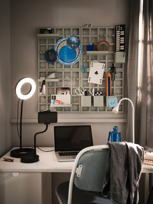 Home office with desk, chair, and multiple grey-green 8-piece storage board sets made of steel, holding office supplies.