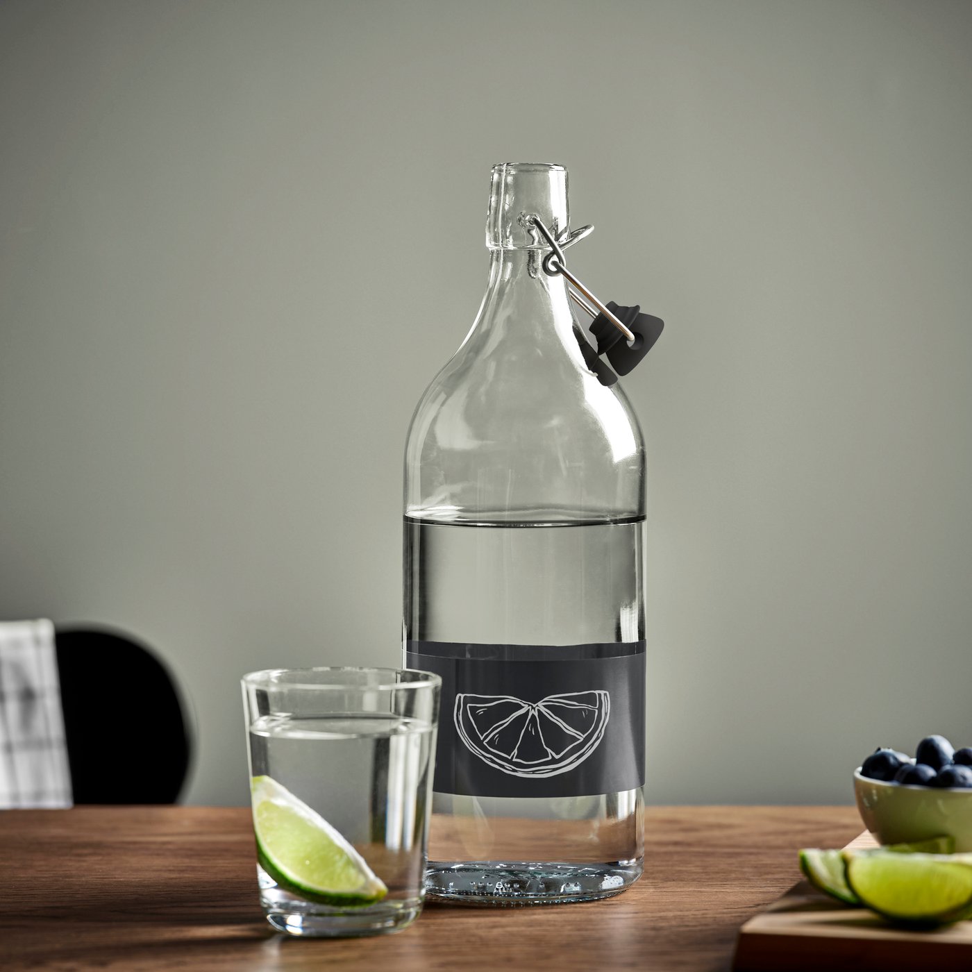 A clear glass/black KORKEN bottle with stopper