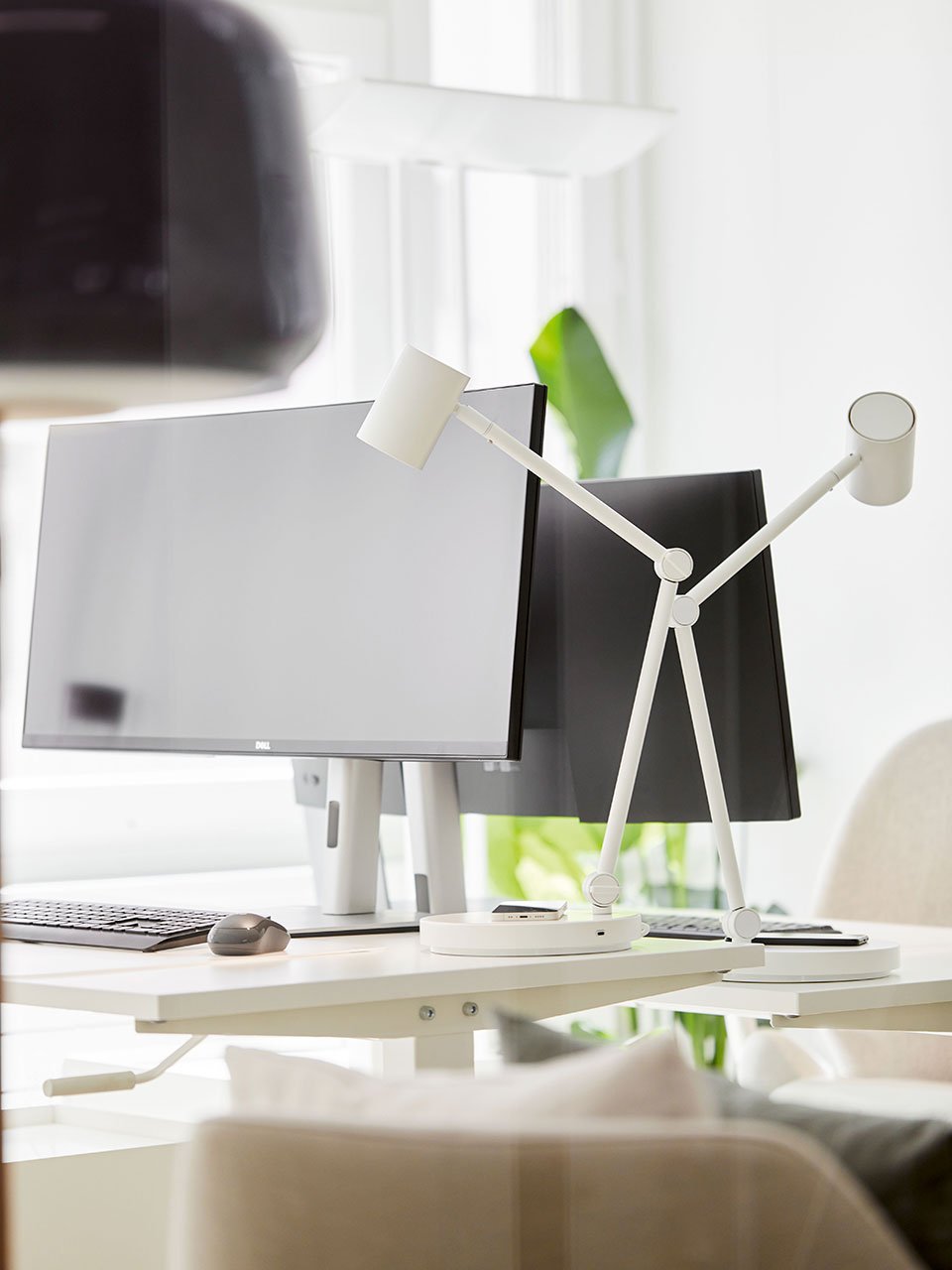 A white NYMÅNE work lamp with wireless charging