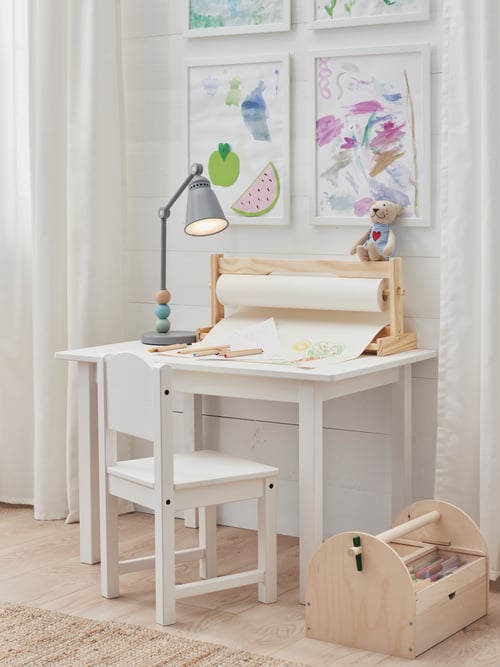 Living room with a children's table, a children's chair, a LED work lamp, a paint draw storage, and a drawing paper roll.