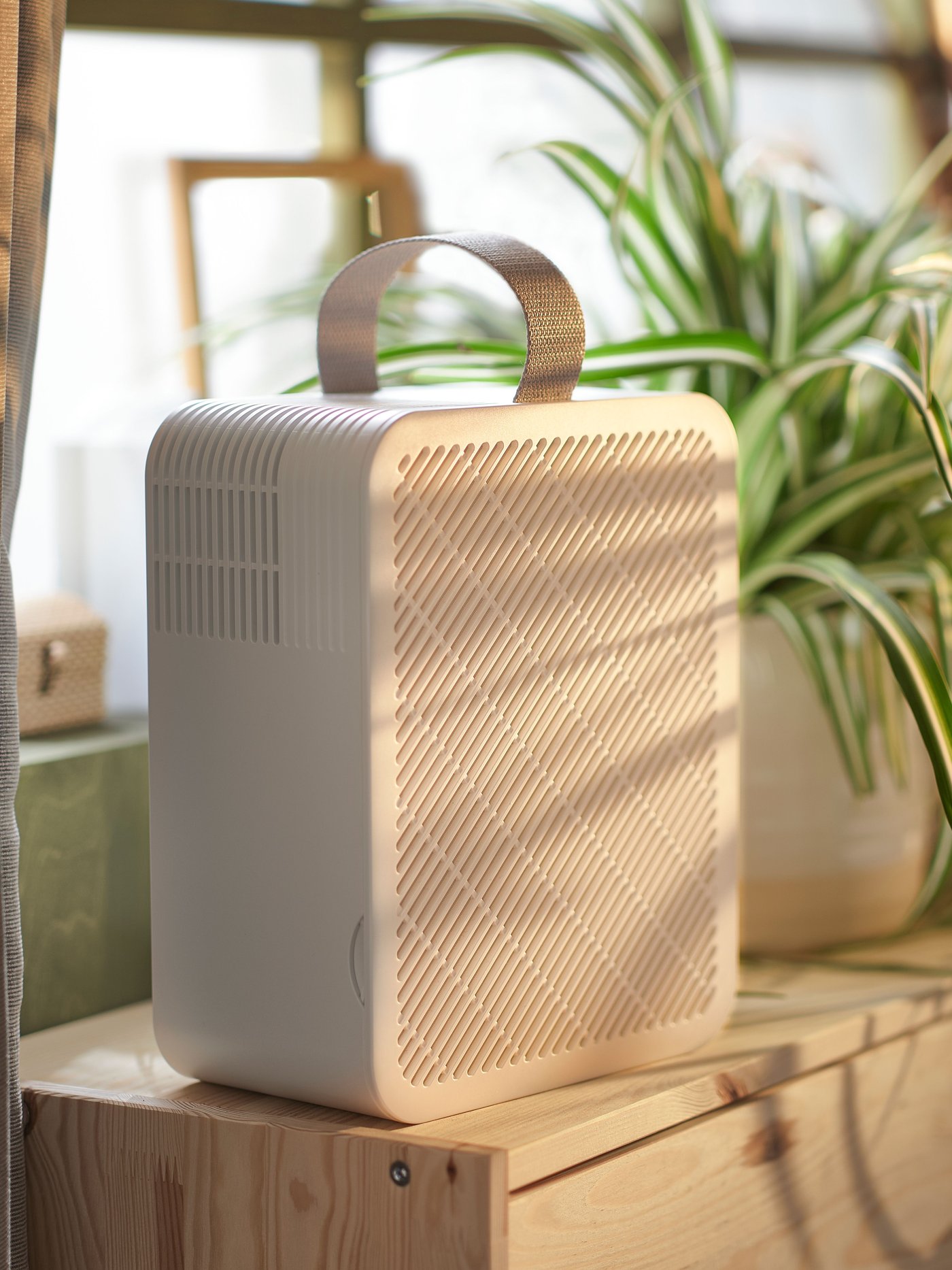 Ein UPPÅTVIND Luftreiniger ist auf einer Fensterbank zu sehen.