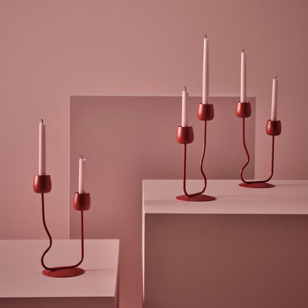 A pink background with new red organic SILVERPÄRON candle holders.