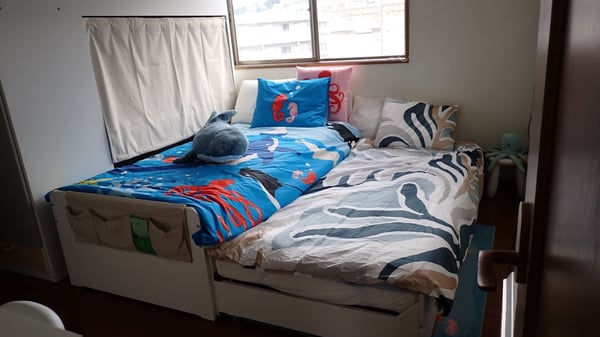 カラフルな掛け布団の上に、サメのぬいぐるみがある。