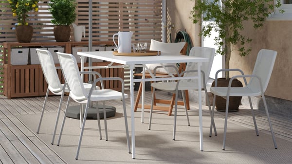 Uno spazio esterno con mobili per la zona pranzo intelligenti e di facile della serie TORPARÖ.