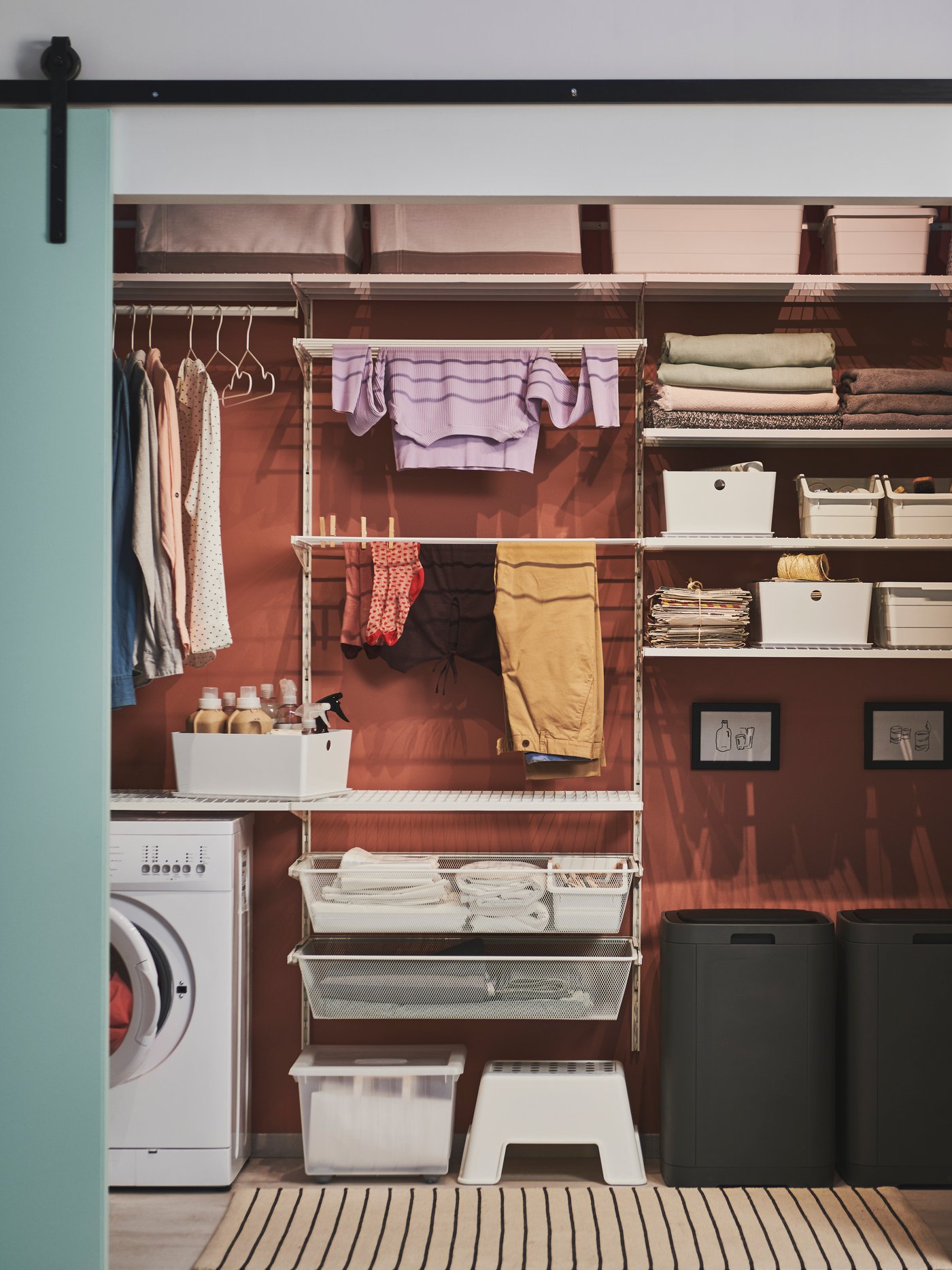 Un lavadero moderno con un conjunto de muebles para lavadero, un cubo con tapa a presión, una caja con tapa y una caja de almacenaje.