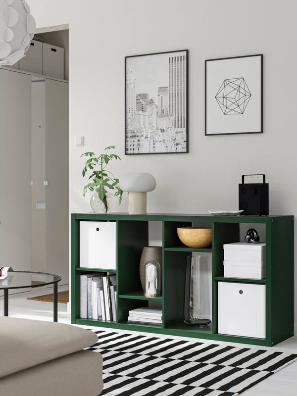 A black LOMVIKEN frame hangs above a dark green KALLAX shelf