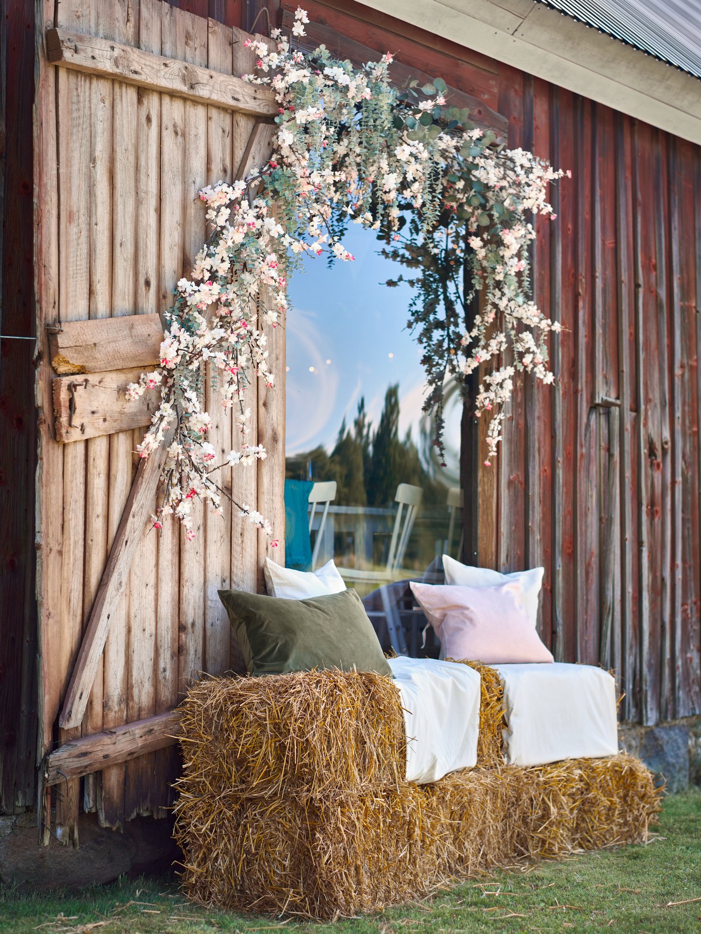 Ein SMYCKA Kunstblumenzweig mit kirschblüten‑/rosafarbenen Blüten im Außenbereich.