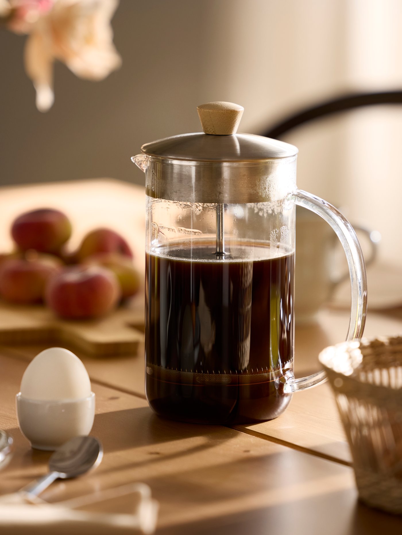 Närbild på IKEA 365+ kaffe-/tebryggare full med kaffe, placerad på ett bord med morgonljus från sidan.