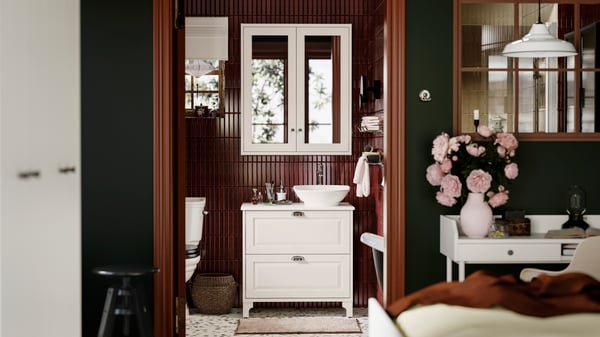 Une salle de bains contemporaine avec sol terrazzo, meuble lavabo TÄNNFORSEN et mur carrelé bourgogne foncé.