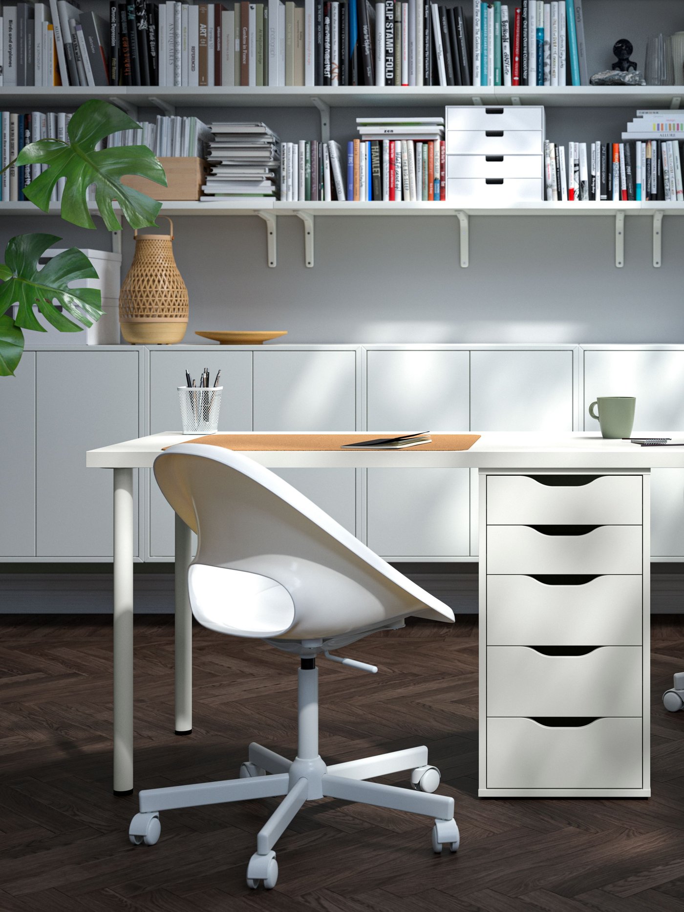 A white ALEX drawer unit supports a long desktop that has two chairs and work areas. The desk is in a modern home office.
