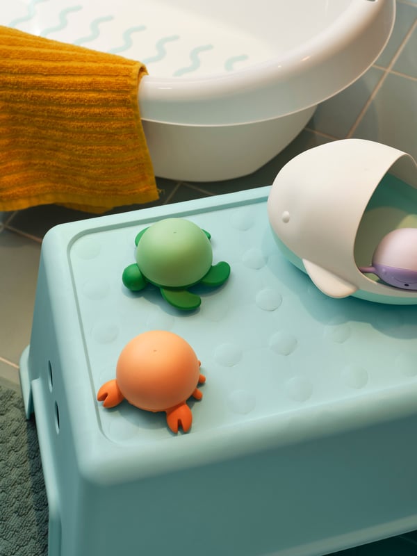 A turquoise FJÄLLKATTFOT bath mat in the NA
