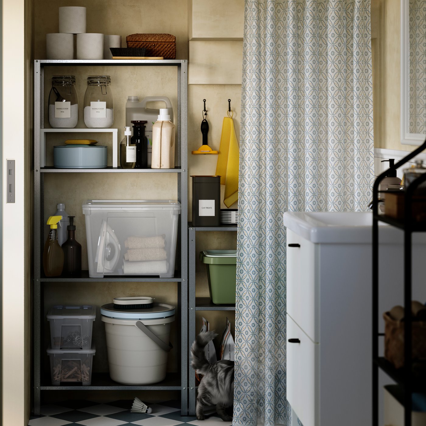A galvanised steel HYLLIS in/outdoor shelving unit holds cleaning supplies and toilet paper rolls in a small bathroom.