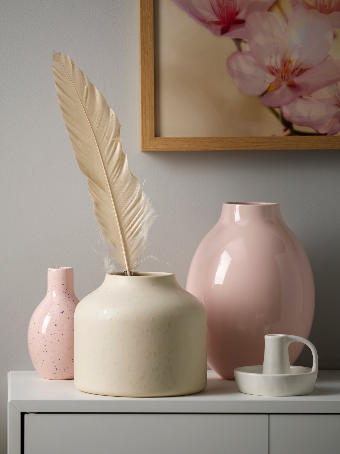 Un mobile con vasi di diverse altezze da toni tenui BLODBJÖRK beige e rosa.