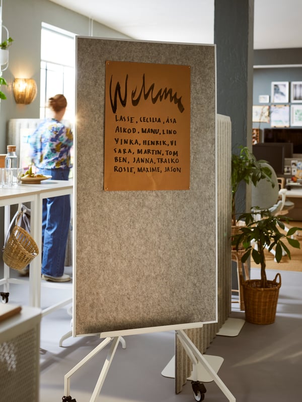 A bright, spacious office with a meeting space fronted by a welcome sign on an ELLOVEN combined whiteboard and noticeboard.