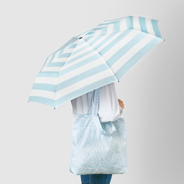 A foldable blue/white KNALLA umbrella