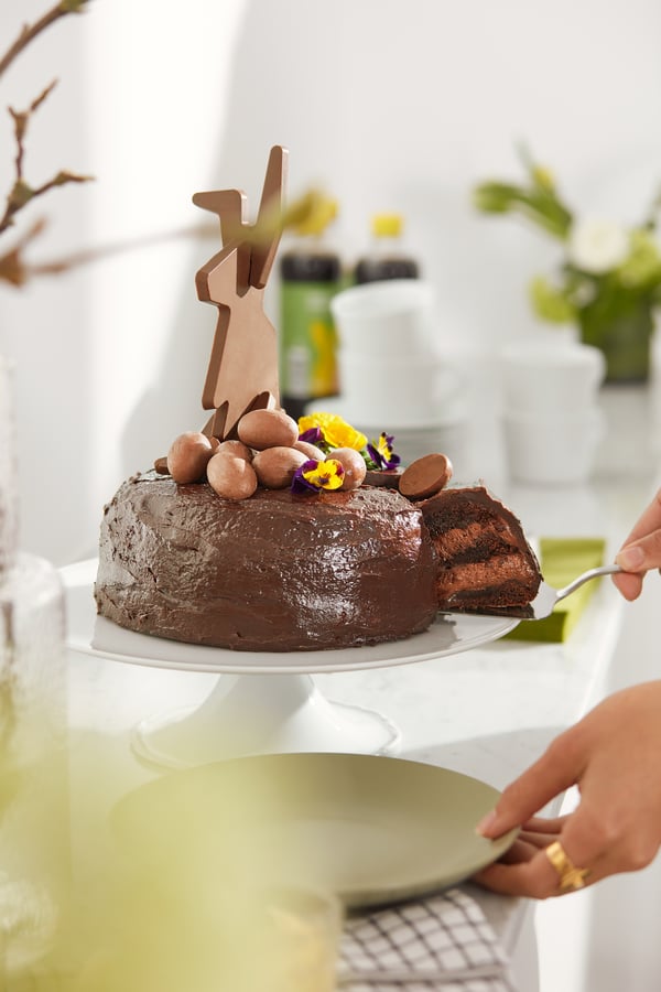 Gâteau au chocolat sur un plateau en train d'être découpé.