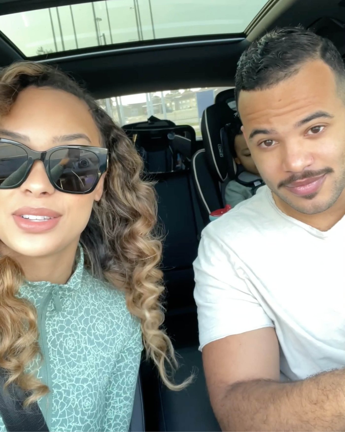 Majka i otac porodice Scott u automobilu, a dete je u dečjem sedištu koje se nazire u pozadini.