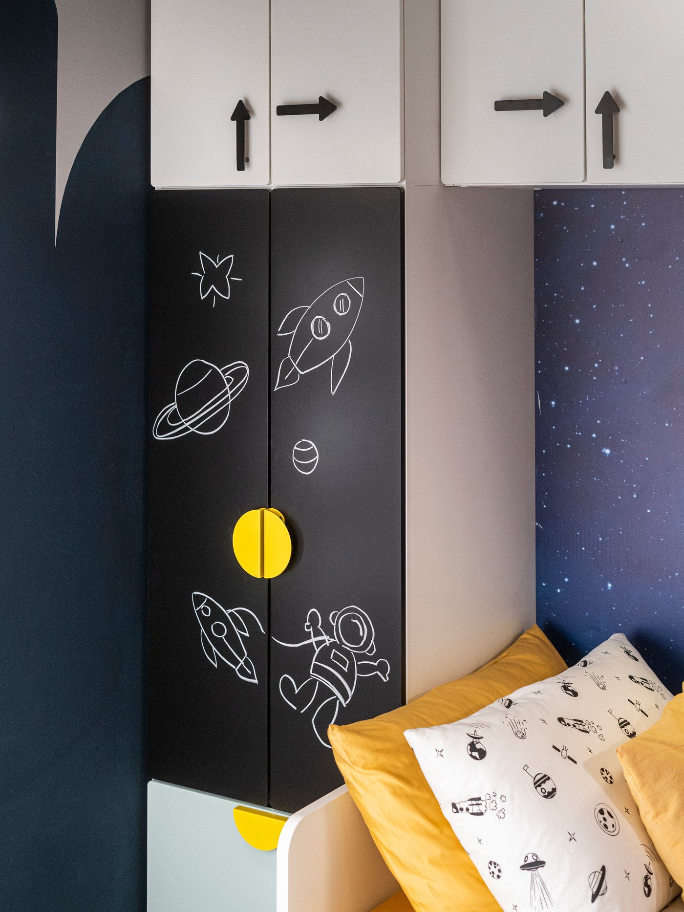 Un angolo di cameretta con un copripiumino e federa AFTONSPARV bianco/nero e accanto un mobile.