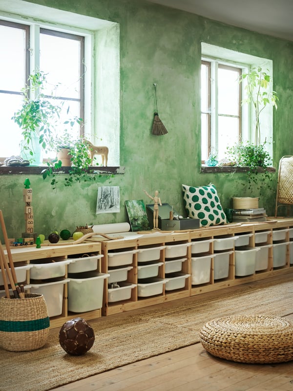 A long row of TROFAST frames filled with TROFAST boxes in a nursery room setting. 