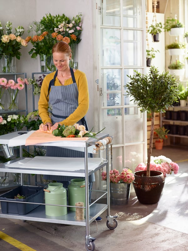 A florist is preparing a bouquet in a flower shop.