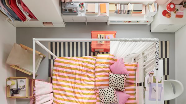 An overhead view of a colourful bedroom with a white VITARNA four poster bed in the centre, covered in SLÅNHÖSTMAL bed linen.