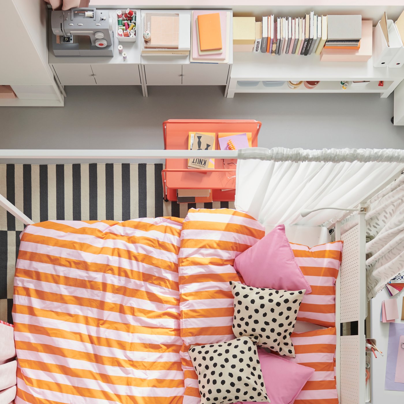 Vista dall'alto di una camera da letto colorata, al centro della quale c'è un letto a baldacchino VITARNA bianco con biancheria da letto SLÅNHÖSTMAL.