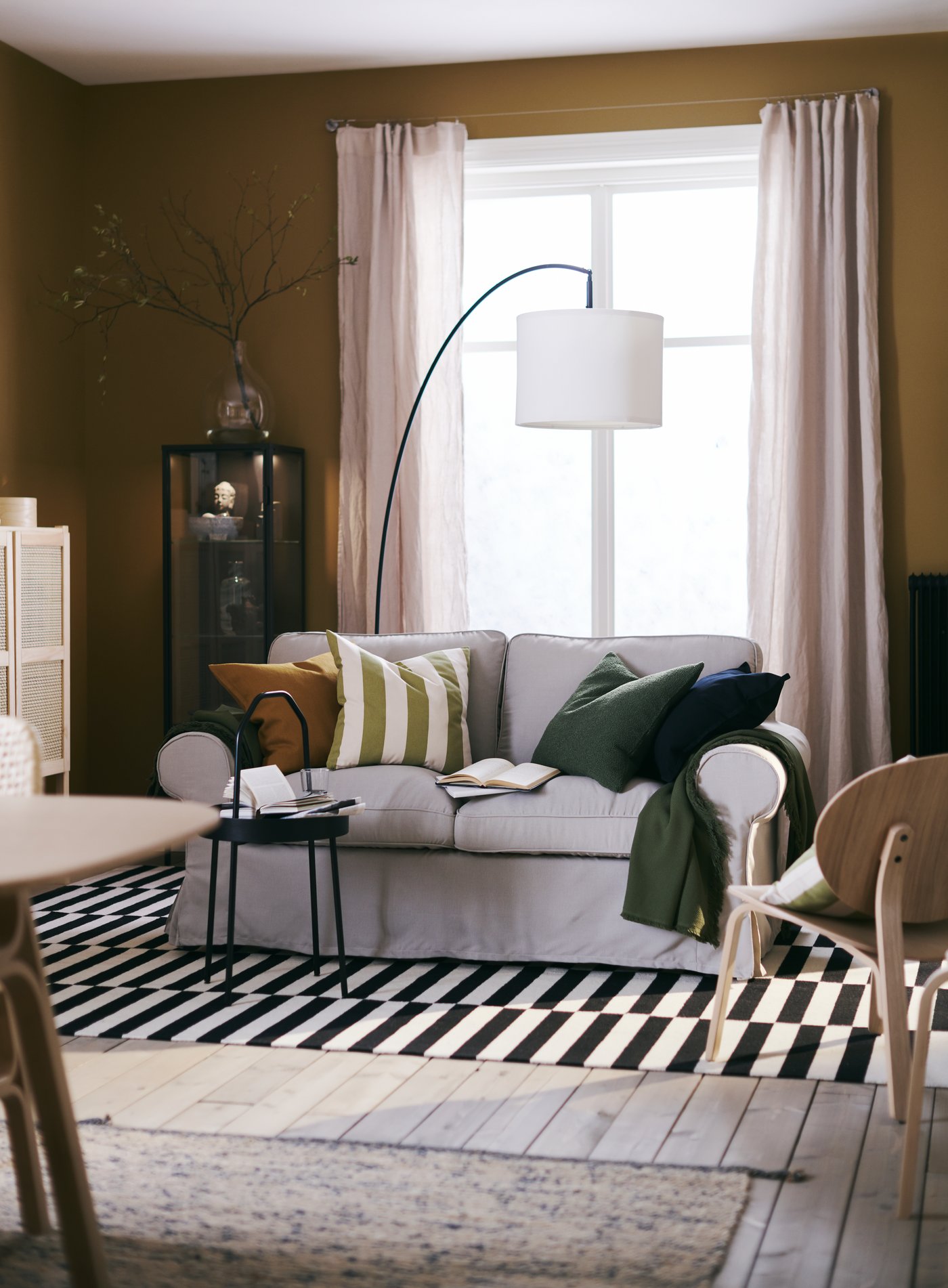 A black SKAFTET floor lamp base, arched in the living room