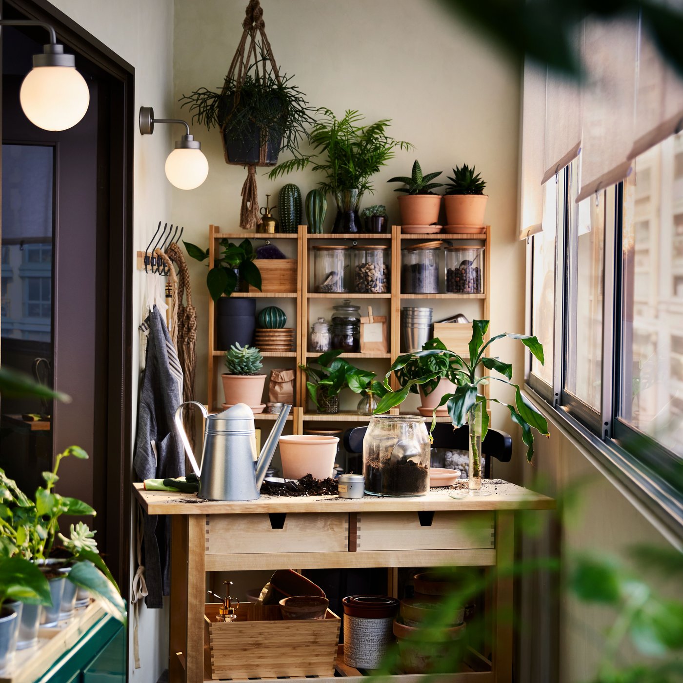 Un carretó de cuina de bedoll, una prestatgeria de bambú, un armari i emmagatzematge de paret amb plantes i articles de jardineria per tot arreu.