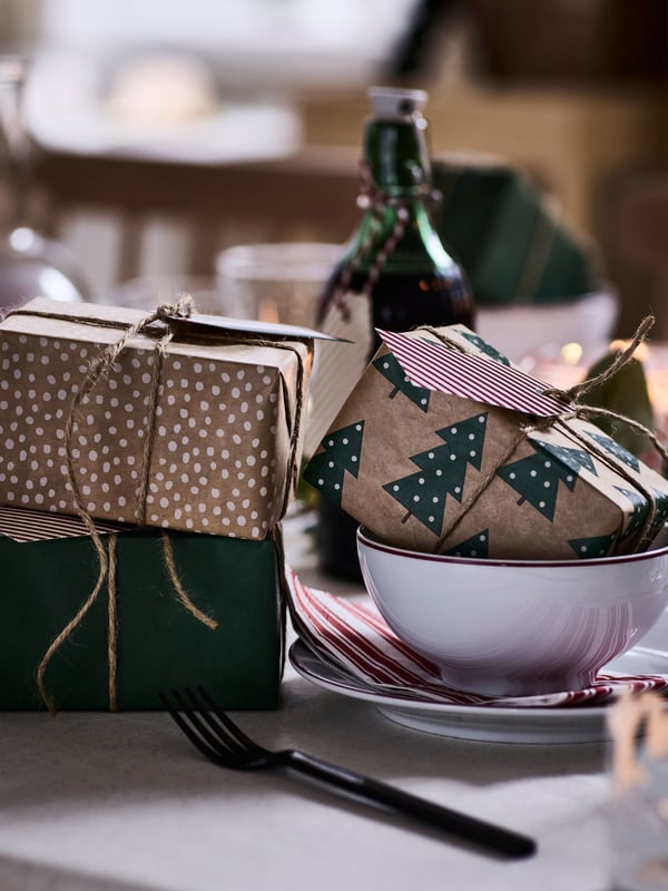 Una mesa con regalos envueltos en papeles navideños VINTERFINT.