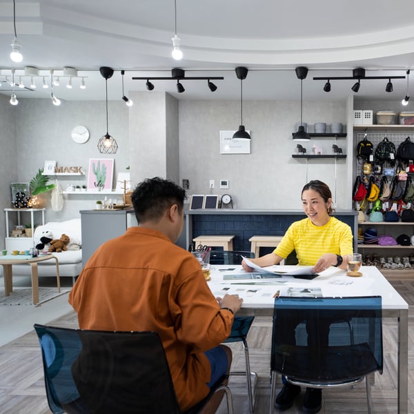 Two people sit at a table and are having a conversation.