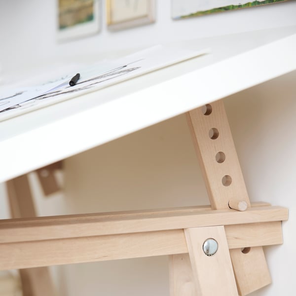 A close-up of the birch MITTBACK trestles in use, with sketches on the white tabletop.