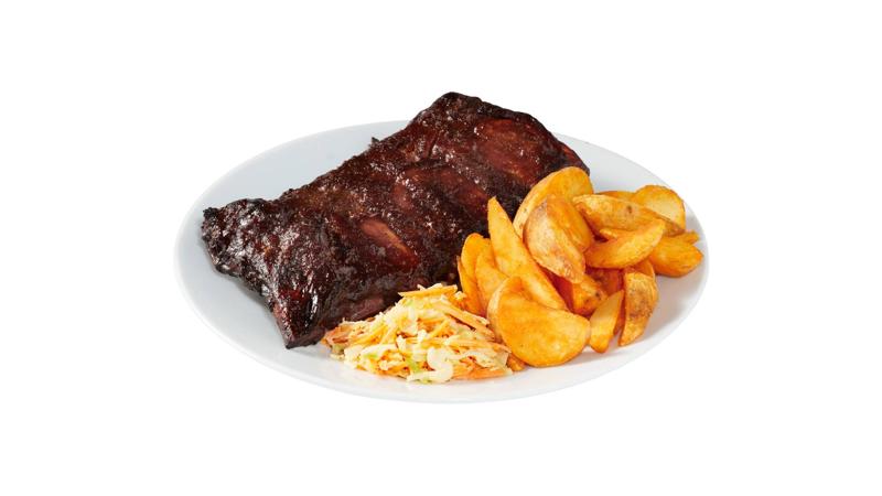 Bord met sappige spareribs, gekruide aardappelpartjes en frisse koolsla, klaar om te serveren.