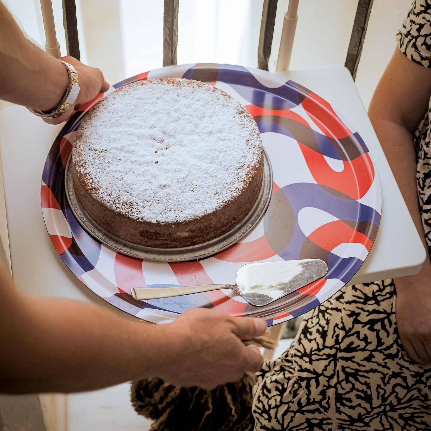 Una donna trasporta una torta fatta in casa su un vassoio FRAMKALLA.