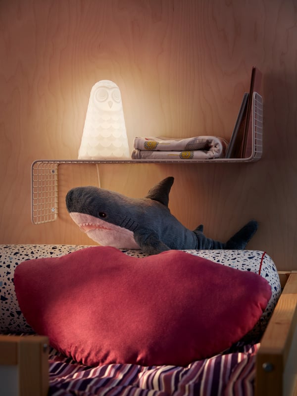 Soft toys from the BLÅVINGAD collection shaped like sea creatures lie on a LANGSTED rug in front of some large windows.
