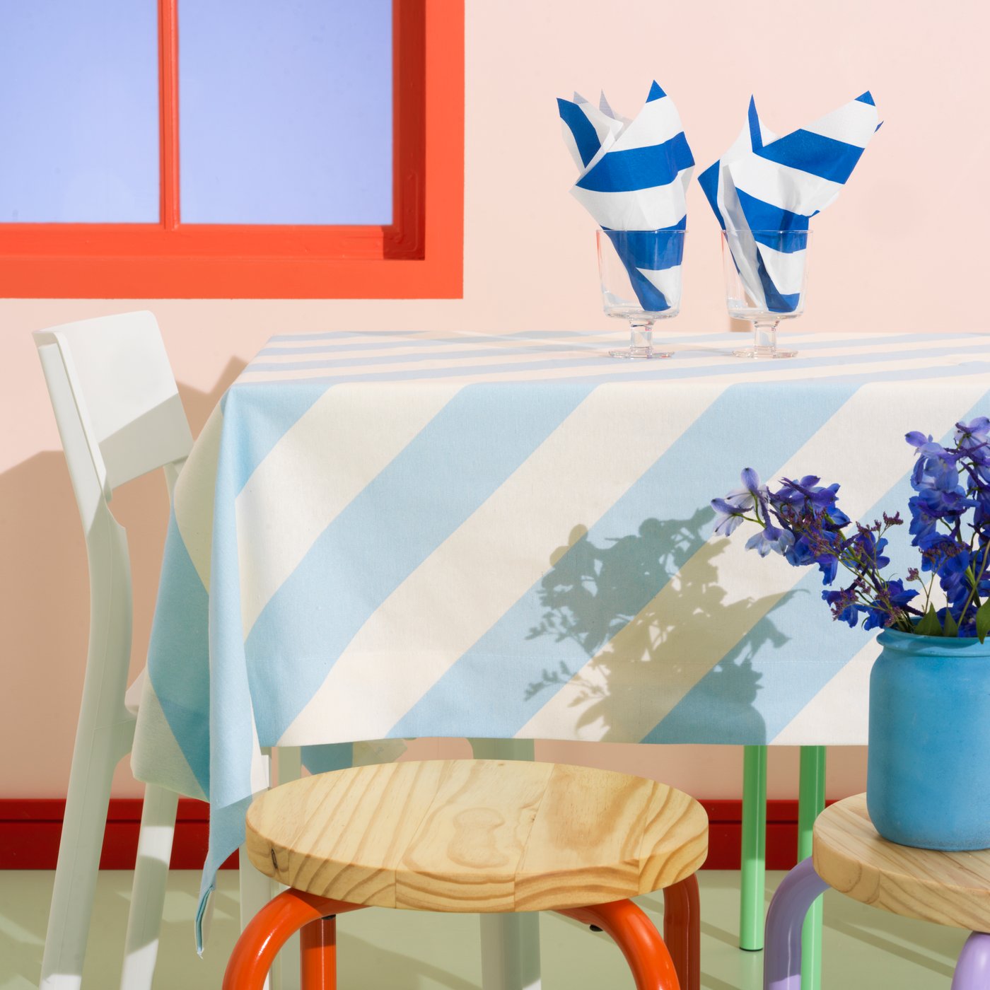 Una mesa cubierta con un mantel de tela precortada LAGERMISPEL se coloca con dos copas con servilletas HAVSKATT dobladas.