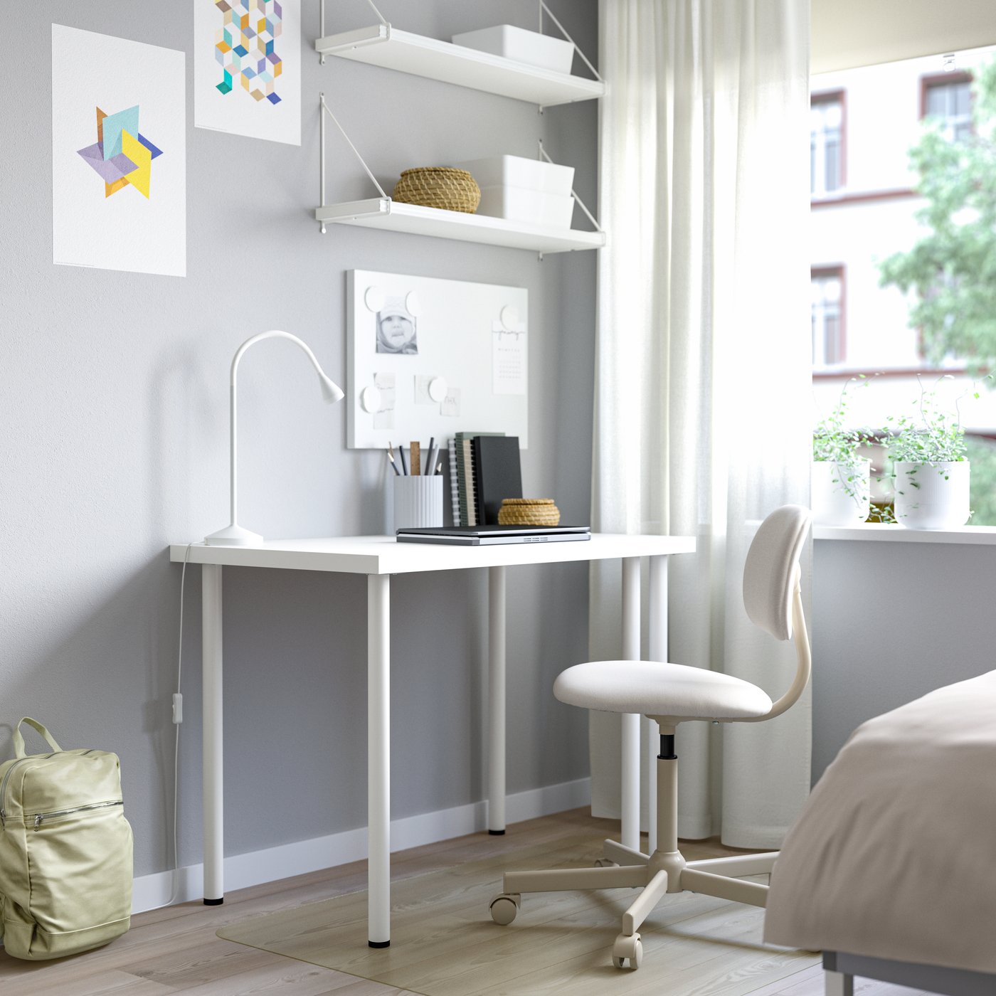 A white ADILS table used as a desk with a white desk lamp and a white desk chair.