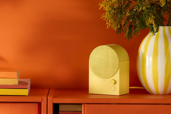 An yellow NATTBAD Bluetooth speaker in the living room
