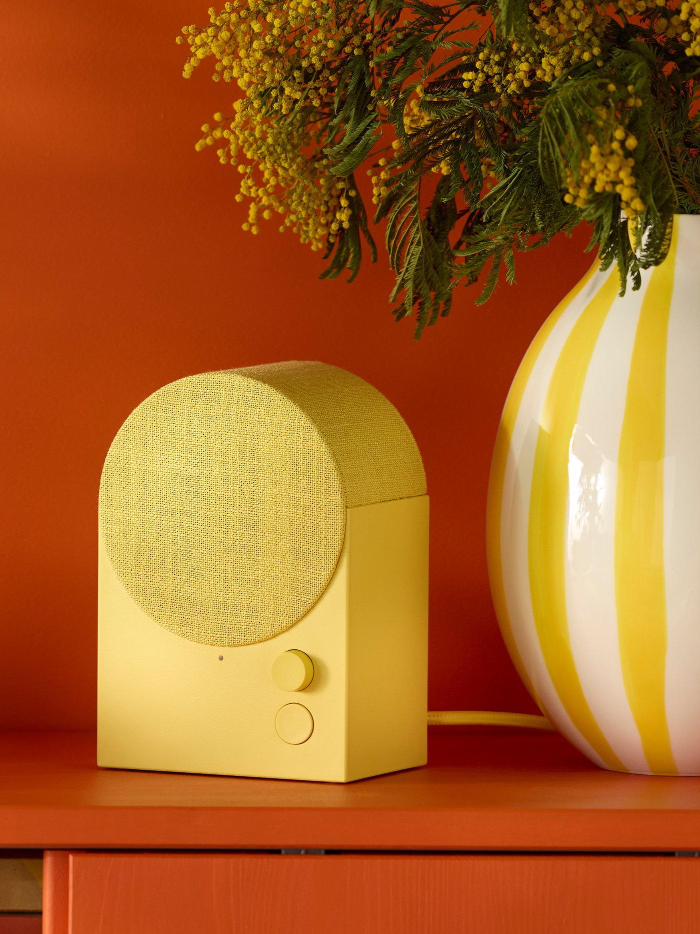 An yellow NATTBAD Bluetooth speaker in the living room