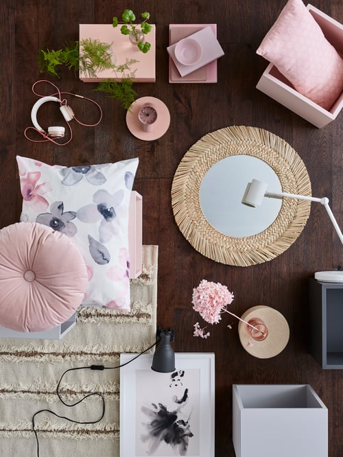 Brown floor featuring multiple items including a round mirror, a shelving unit, headphones, a rug, a work lamp, and cushions.