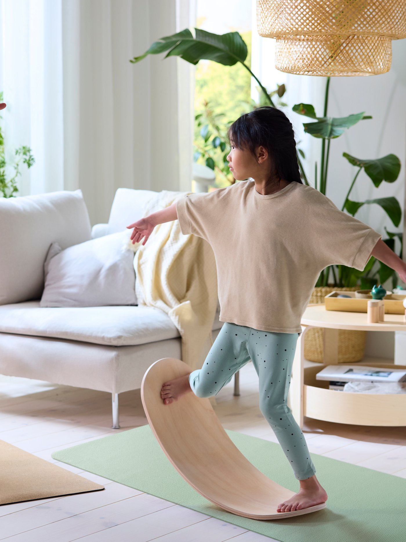 A wood GREJSIMOJS balance board for children in the living room