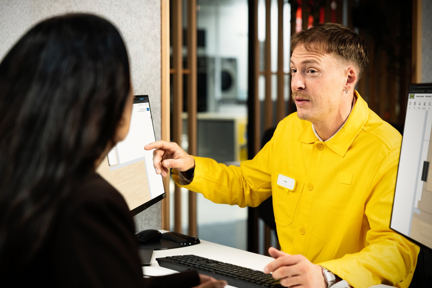 Ein IKEA Mitarbeiter berät eine Kundin beim Küchenkauf