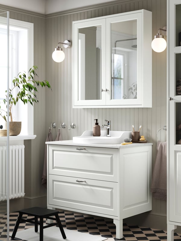 A white TÄNNFORSEN set with a wash-stand with drawers, a RUTSJÖN semi-recessed wash-basin and a mirror cabinet.