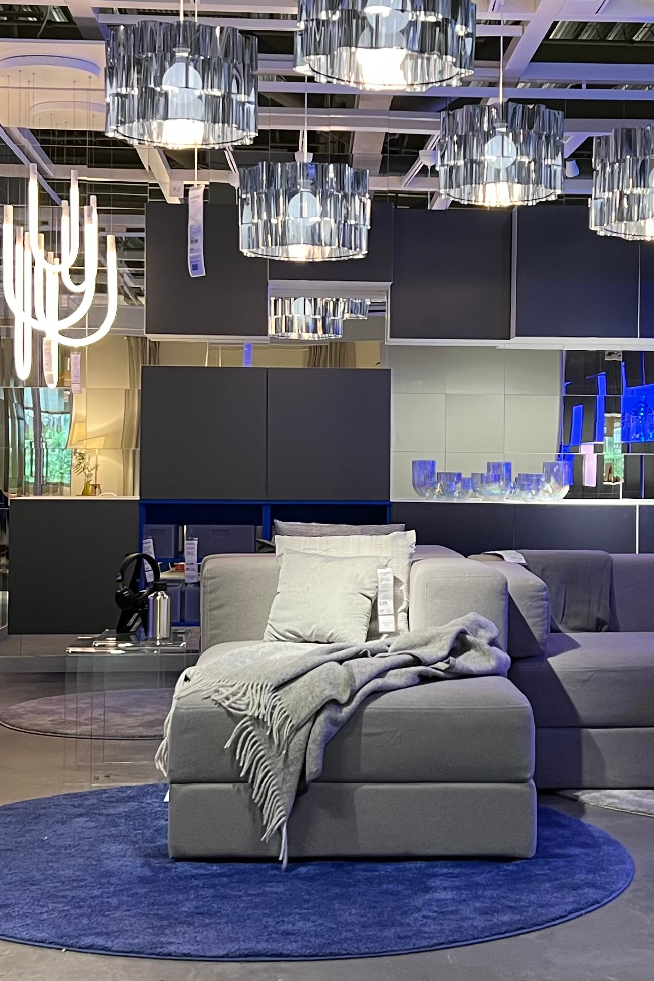 Een futuristisch uitziende woonkamer met veel glanzende materialen en blauw licht