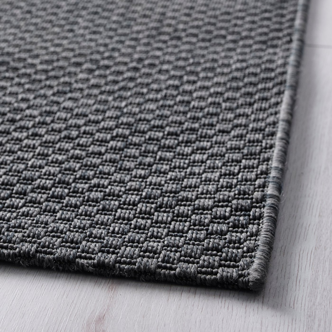 A dark grey MORUM rug flatwoven, in/outdoor