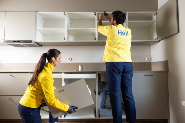 A MAN AND A WOMAN ASSEMBLING A KITCHEN