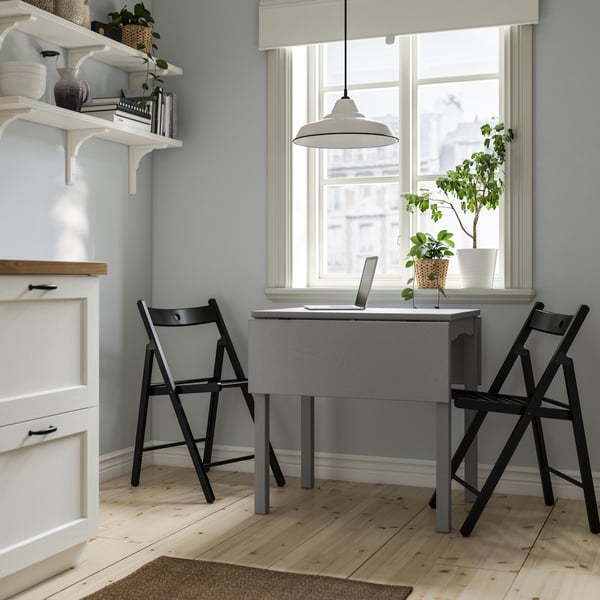 A grey/black HAUGA table and 2 folding chairs