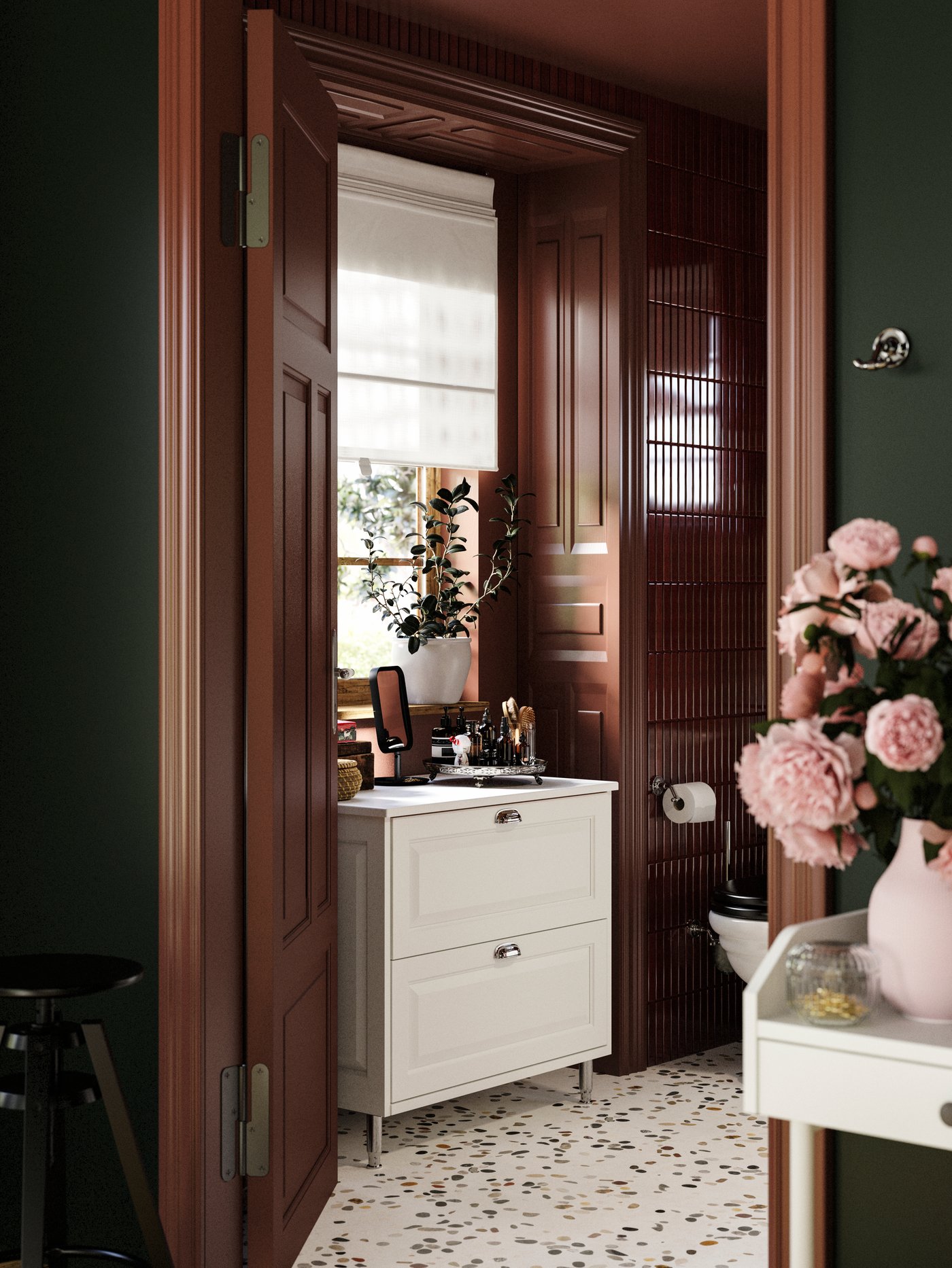 Badrum med TÄNNFORSEN tvättställ med lådor, vas med blommor, vinröda kakelplattor och terrazzo-golv.