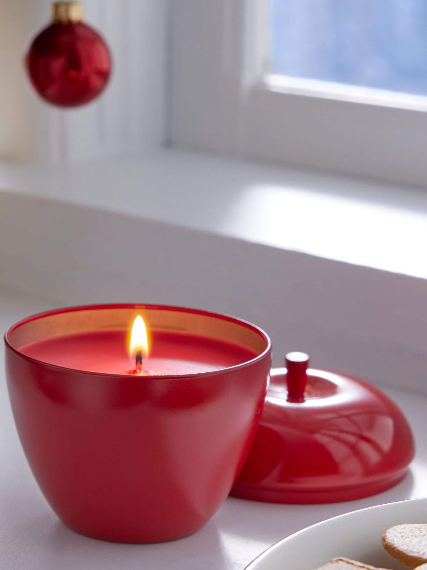 Una mesa con tres velones dorados encendidos. En el fondo se ven dos candelabros con unas velas blancas también encendidas.