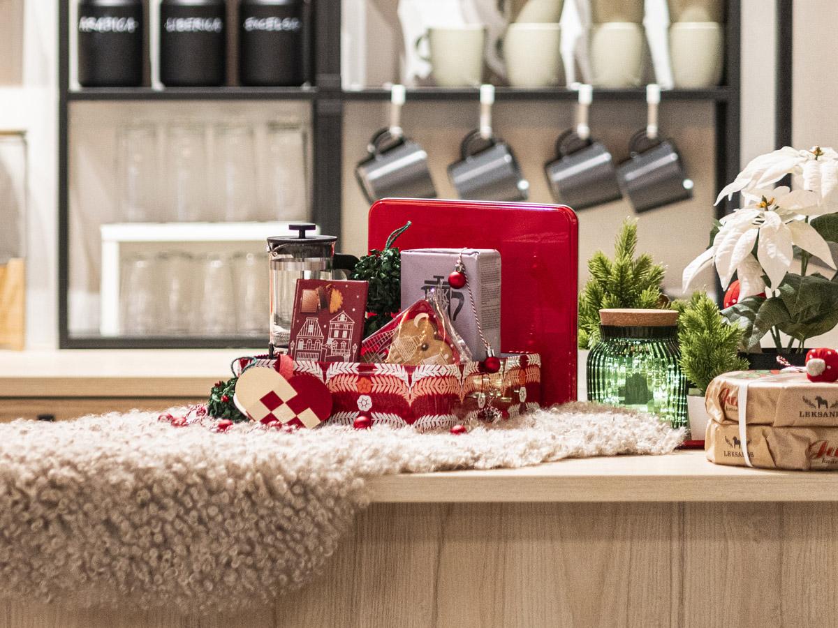 Atmosfera di festa in un angolo di cucina. Sopra una pelle di pecora, idee regalo e decori natalizi creano una scena accogliente.