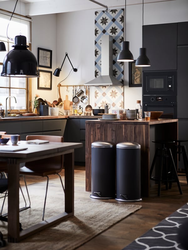 A METOD kitchen with a kitchen tile backsplash, wooden kitchen island and two MJÖSA pedal bins.